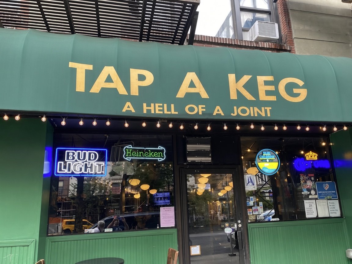Tap a Keg storefront on Broadway: green awning, gold letters that read TAP A KEG, A Hell of a Joint